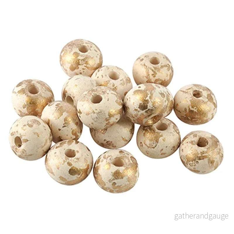 Porslinspärla – Rund vit med guldstänk, 12mm 1 styck