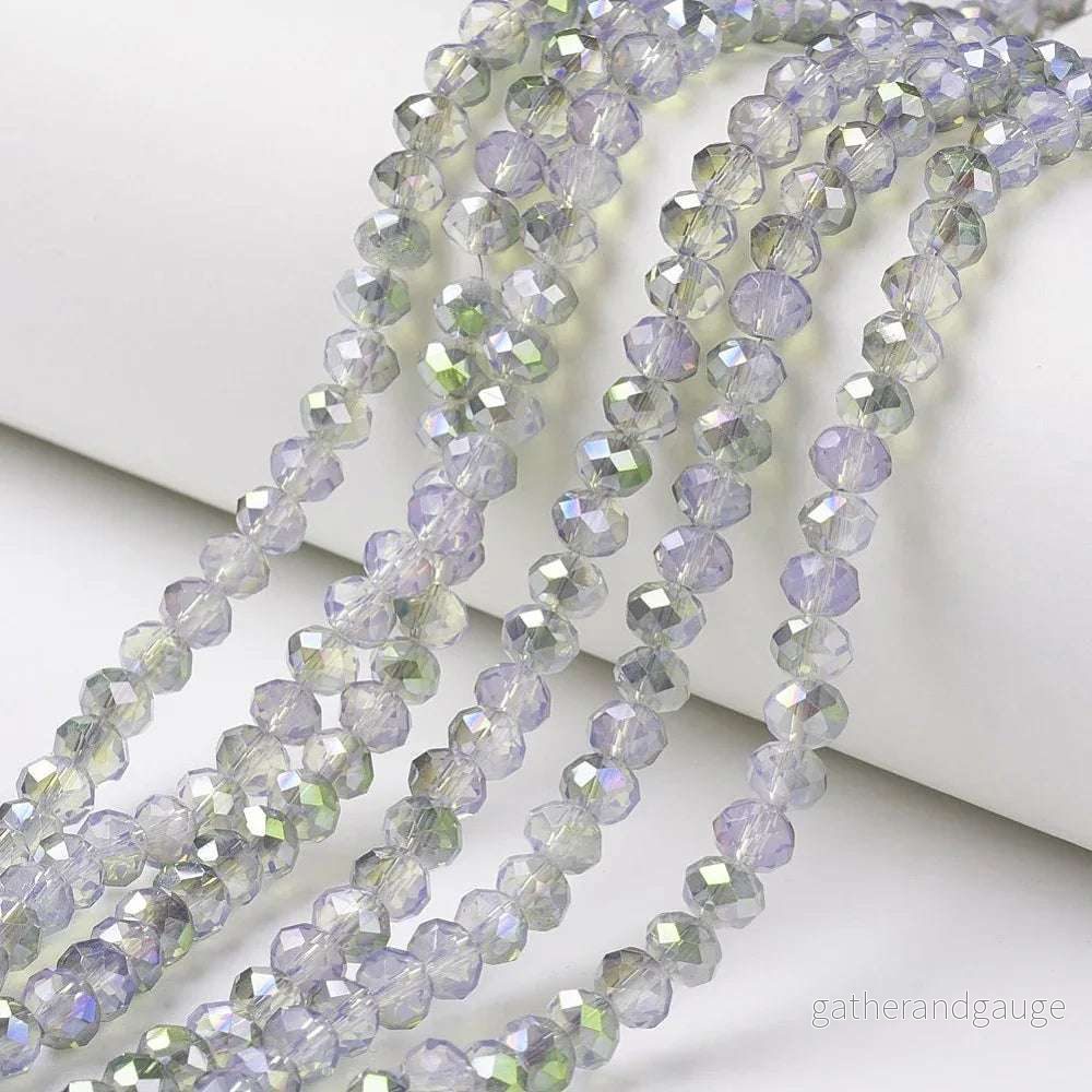 Facetterade glaspärlor - Halvopak Lavender med grönt shimmer, 6x5mm 1 sträng - Bild 2