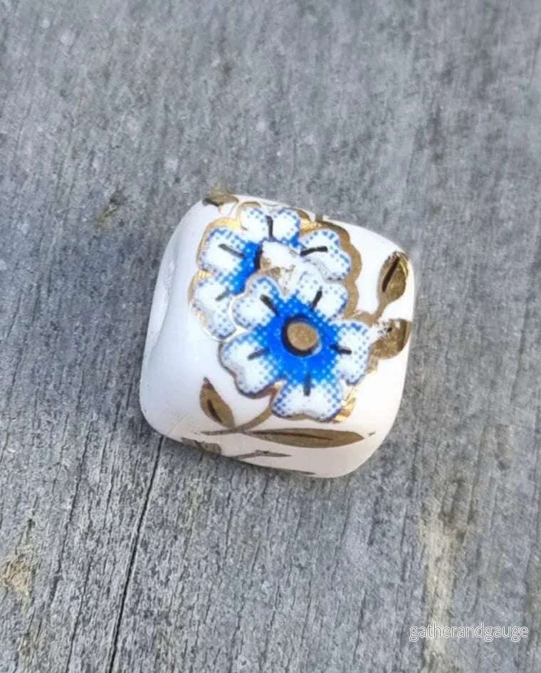 Porslinspärla Kub – Vit/Blå/Guld med Blommor 10mm 1 styck Porslinspärla Kub – Vit/Blå/Guld med Blommor 10mm 1 styck