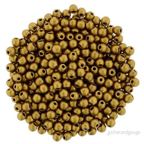 Tjeckiska Druk (Runda) – Matte Metallic Antique Gold 2mm, 50-pack