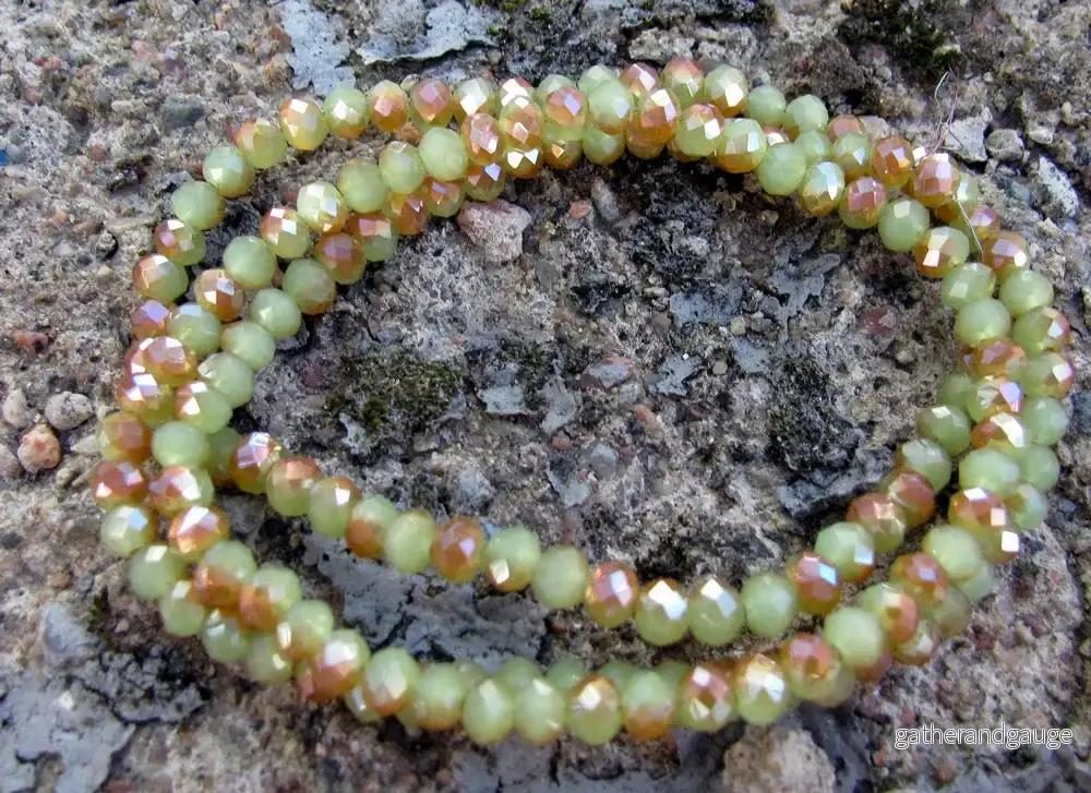 Facetterade glaspärlor – Grön/Guld 4x3mm, 1 sträng
