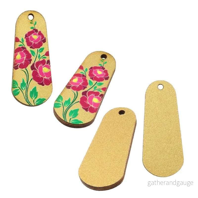 Hänge / Berlock Trä – Oval med blommor, guld 15x36mm 1 styck Hänge / Berlock Trä – Oval med blommor, guld 15x36mm 1 styck