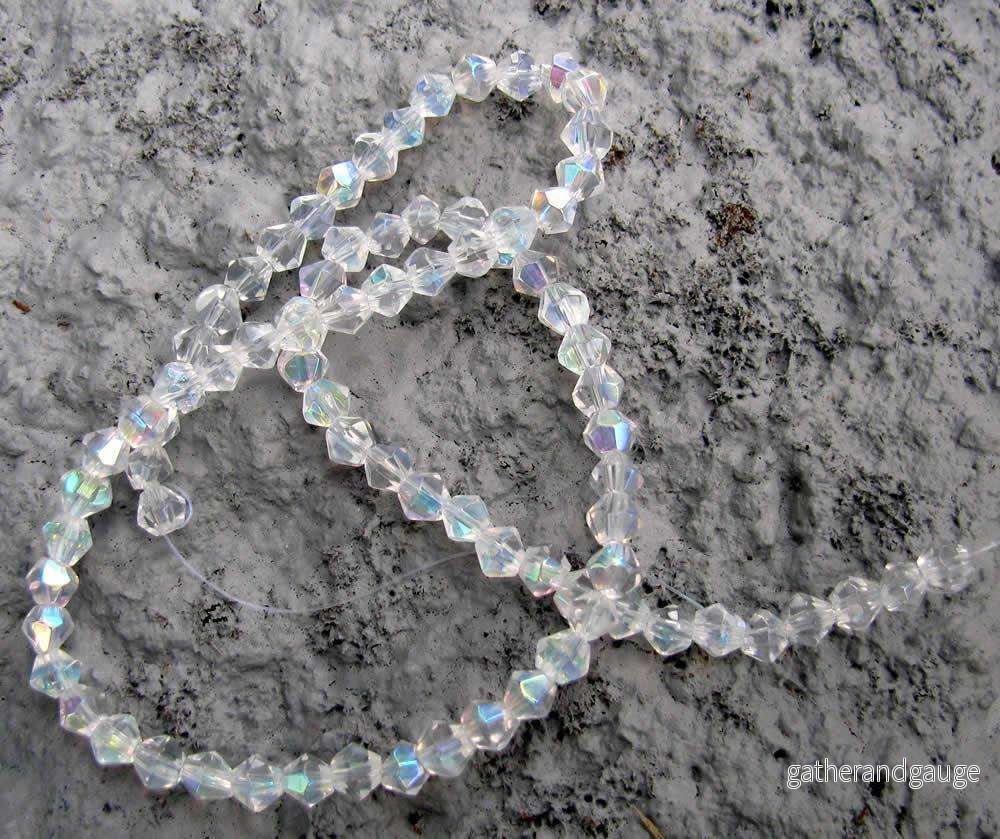 Glaspärlor Bicone – Klar med AB, 4mm, 1 sträng Glaspärlor Bicone – Klar med AB, 4mm, 1 sträng