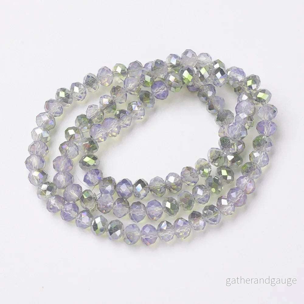 Facetterade glaspärlor - Halvopak Lavender med grönt shimmer, 6x5mm 1 sträng