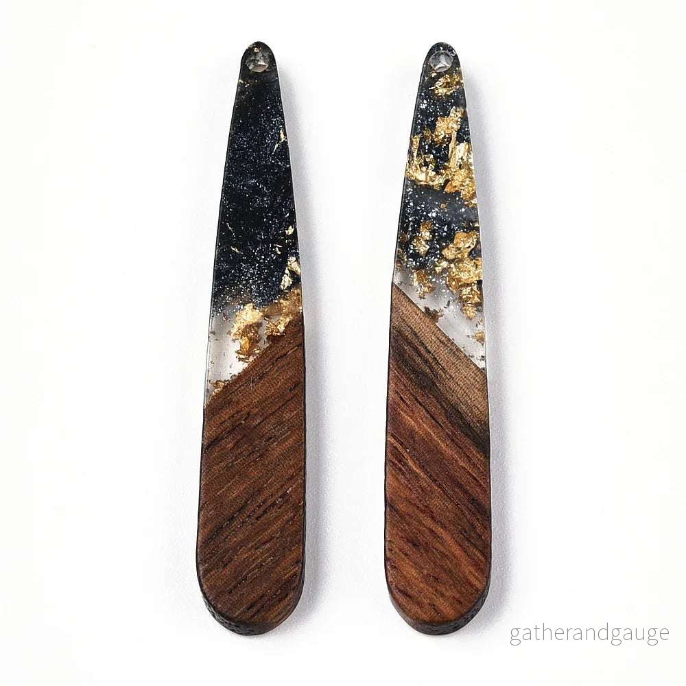 Hänge Trä och Resin – Droppe Svart med Guldflakes 44×7,5mm 1 styck Hänge Trä och Resin – Droppe Svart med Guldflakes 44×7,5mm 1 styck
