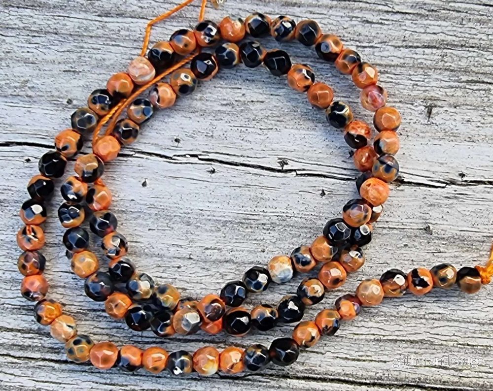 Agat facetterad rund – Orange/svart 4mm, 1 sträng